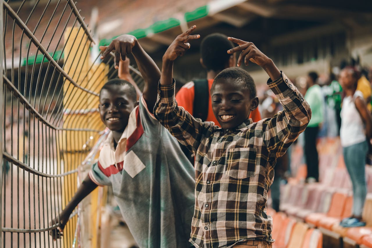 Happy children expressing excitement at a lively outdoor sports event.