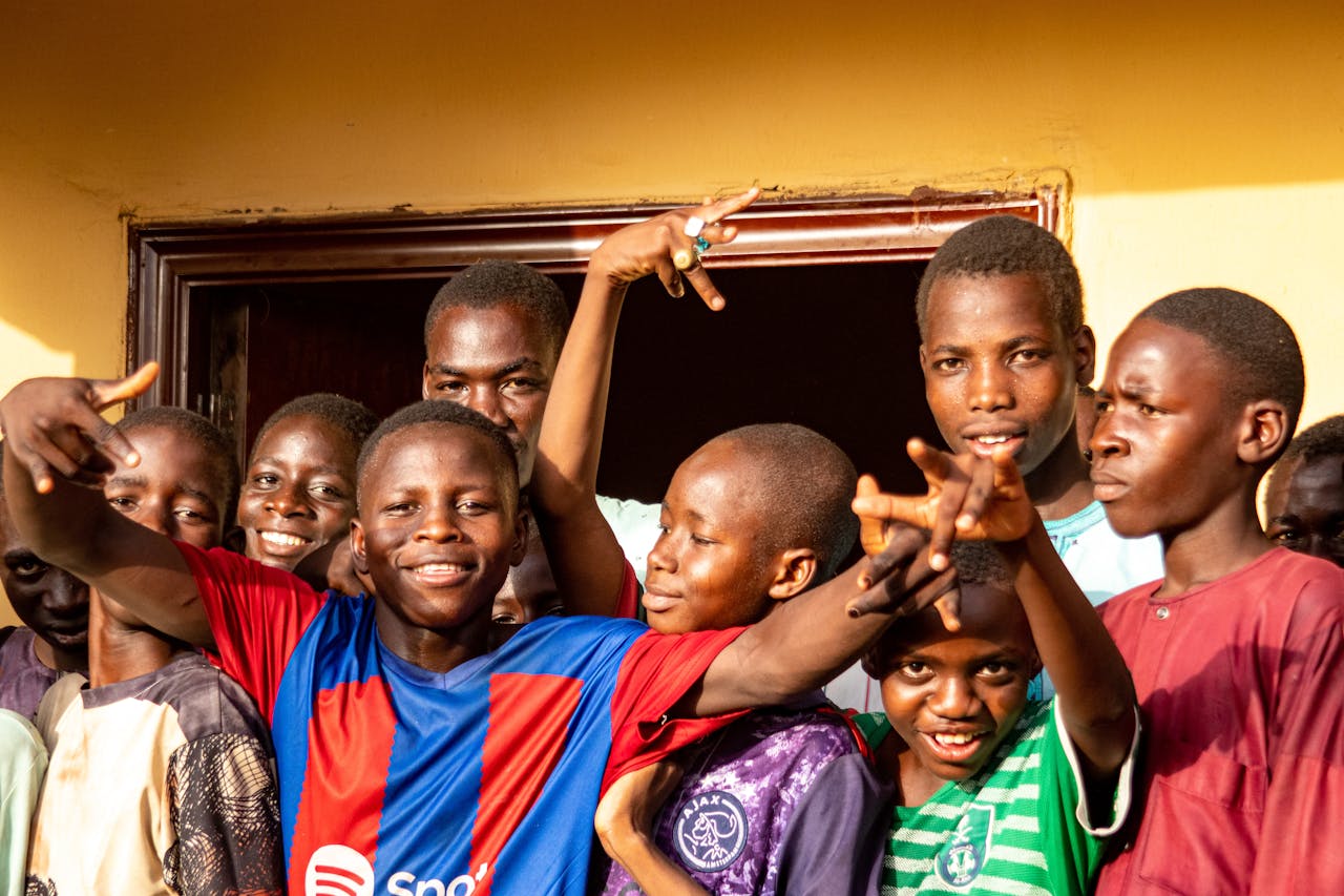 A lively group of boys joyfully posing and smiling in Maiduguri, Nigeria.